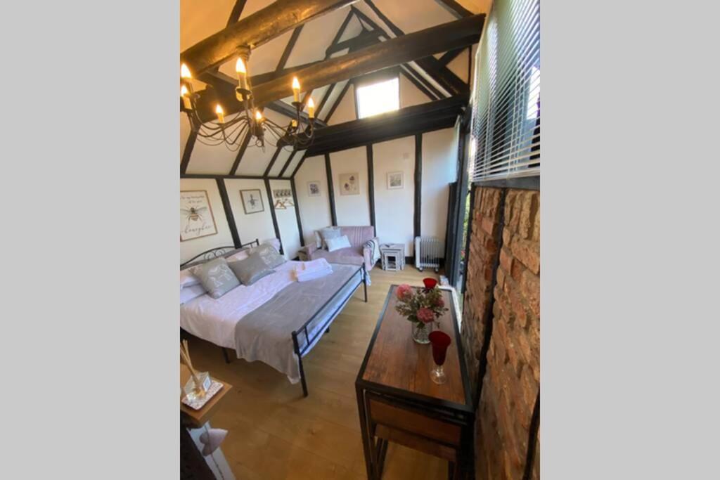 a bedroom with a bed and a table in a room at Windsor/Ascot/Bracknell beautiful barn in Bracknell