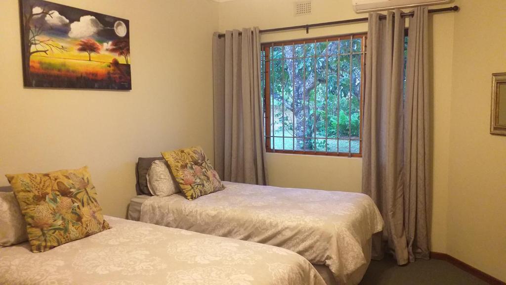 Un dormitorio con dos camas y una ventana. en Hooked on 6 Fish Eagles, en St Lucia