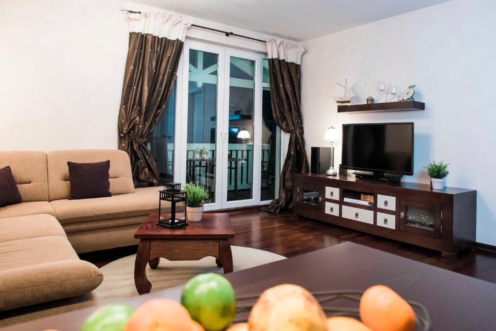 een woonkamer met een bank en een tv bij Residenz Prorer Wiek App 10 strandnah, mit Balkon by Unsere Urlaubszeit in Binz