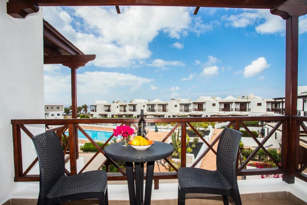 balcón con mesa, sillas y vistas en Casa Del Mar, en Playa Blanca