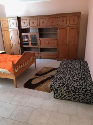 a bedroom with a bed and a dresser at Bem apartman in Jászárokszállás