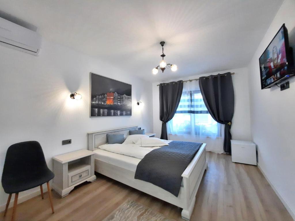 een slaapkamer met een bed en een stoel en een tv bij Casa Mora in Deva