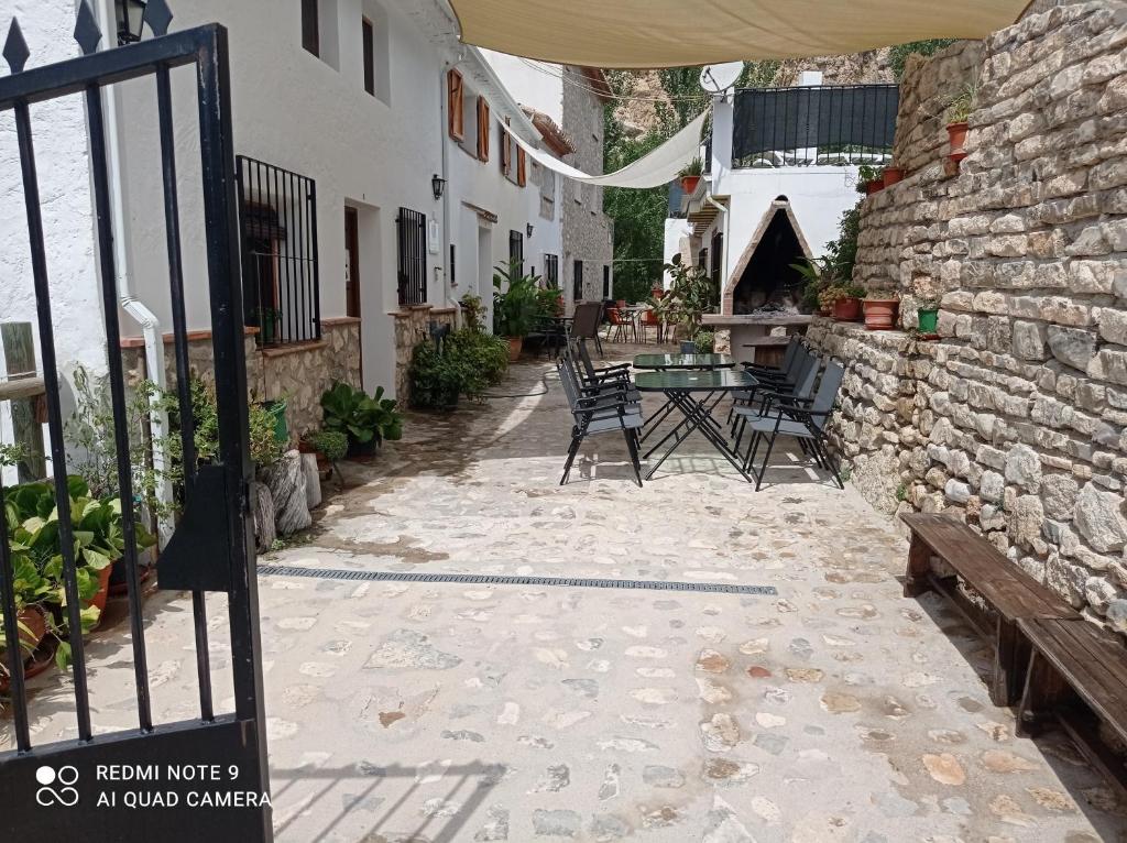 een patio met stoelen en een tafel naast een gebouw bij Alojamiento Rural El Molino De La Cerrada in Castril