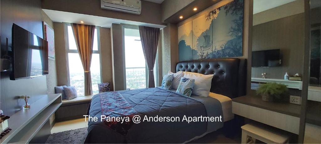 a bedroom with a bed with a large window at The Paneya@Anderson Apartment in Surabaya