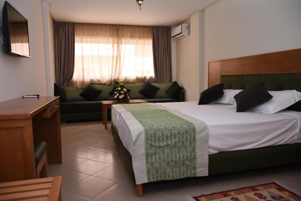 um quarto de hotel com uma cama e um sofá em Hotel Residence Imiplage em Agadir