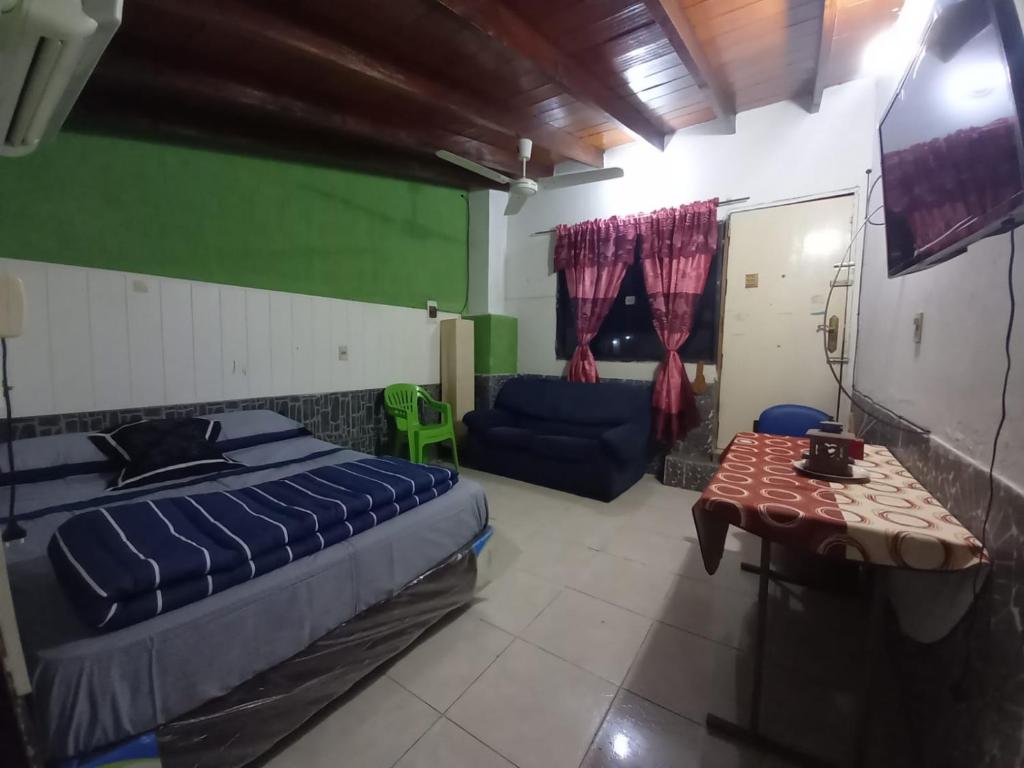 a bedroom with a bed and a couch and a tv at HERMOSO APARTAMENTO MONOAMBIENTE ZONA SHOPPING in Colonia Mariano Roque Alonso