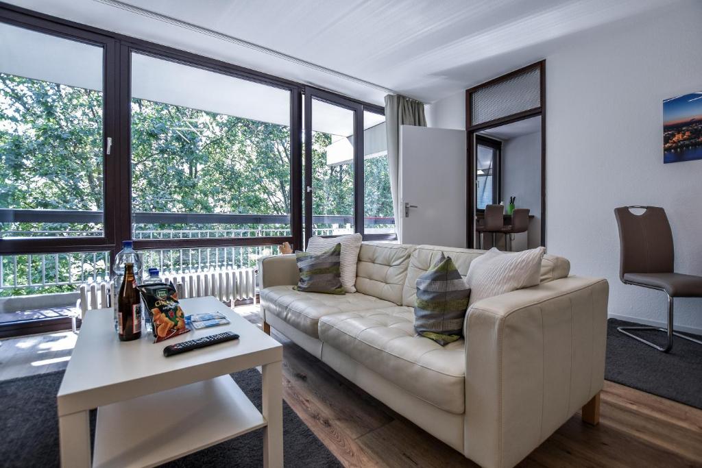 ein Wohnzimmer mit einem Sofa und einem Tisch in der Unterkunft Domicile Cologne in Köln