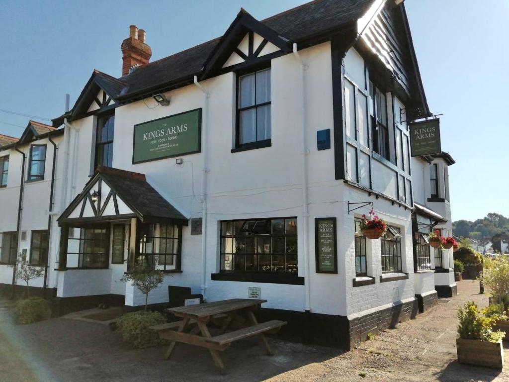 a white building with a picnic table in front of it at The Kings Arms Otterton in Budleigh Salterton