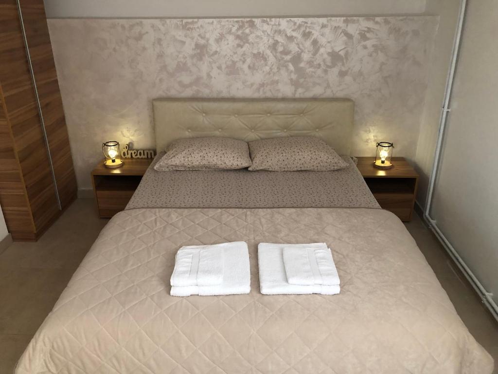 a bedroom with a bed with two towels on it at Apartmani Tesla in Soko Banja