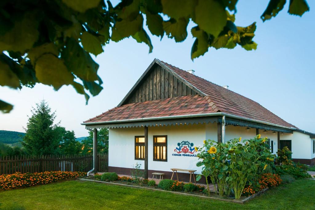 una pequeña casa blanca con techo marrón en Csenger Vendégházak, en Mátraverebély