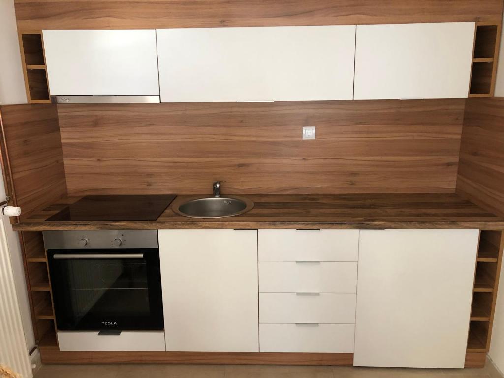 a kitchen with white cabinets and a sink at Apartmani Tesla in Soko Banja
