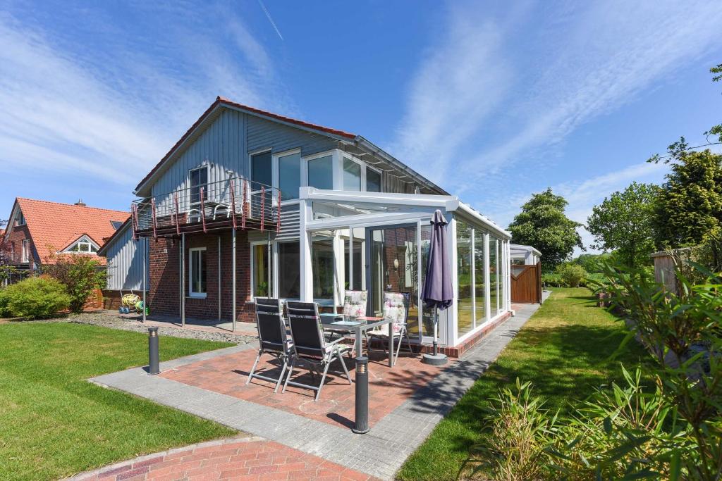 Casa con patio con mesa y sillas en Ferienwohnungen im Haus Nordlichter, en Holtgast