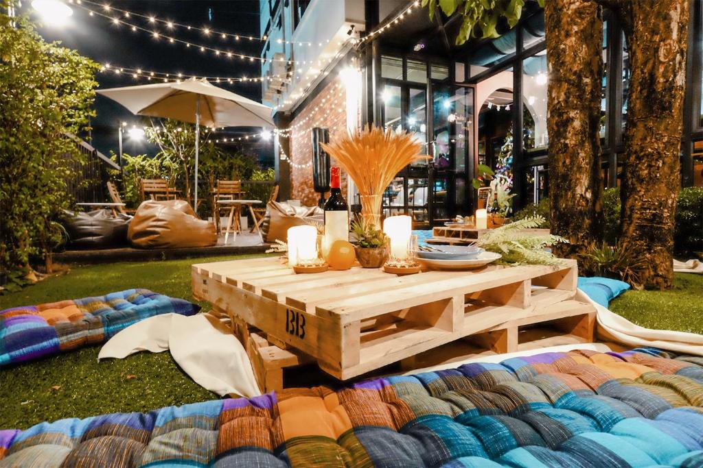 a picnic table in a yard with a blanket at Wayha Hostel Don Mueang Airport in Bangkok