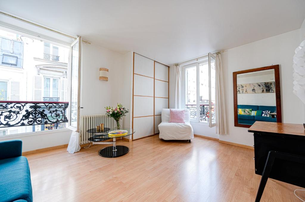 salon z kanapą i krzesłem w obiekcie Bright and lovely parisian apartment w Paryżu