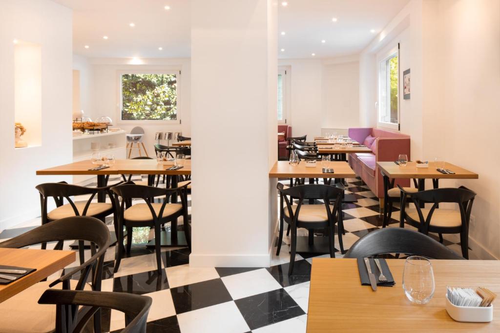 un ristorante con tavoli e sedie in legno e pavimento a scacchi di Hotel Morfeo a Milano