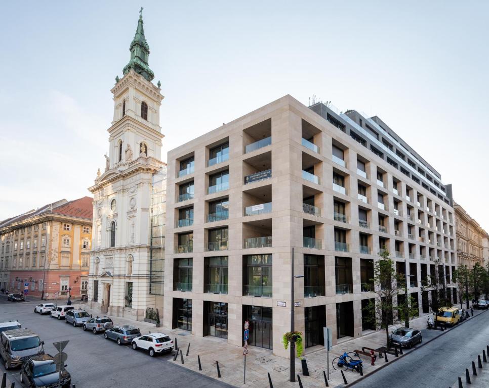 un gran edificio blanco con una torre de reloj en una calle en Emerald Downtown Luxury Suites with Hotel services, en Budapest