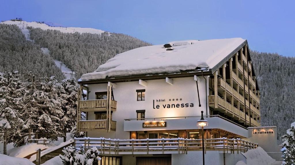 un bâtiment avec de la neige au-dessus dans l'établissement Hôtel Vanessa, à Verbier