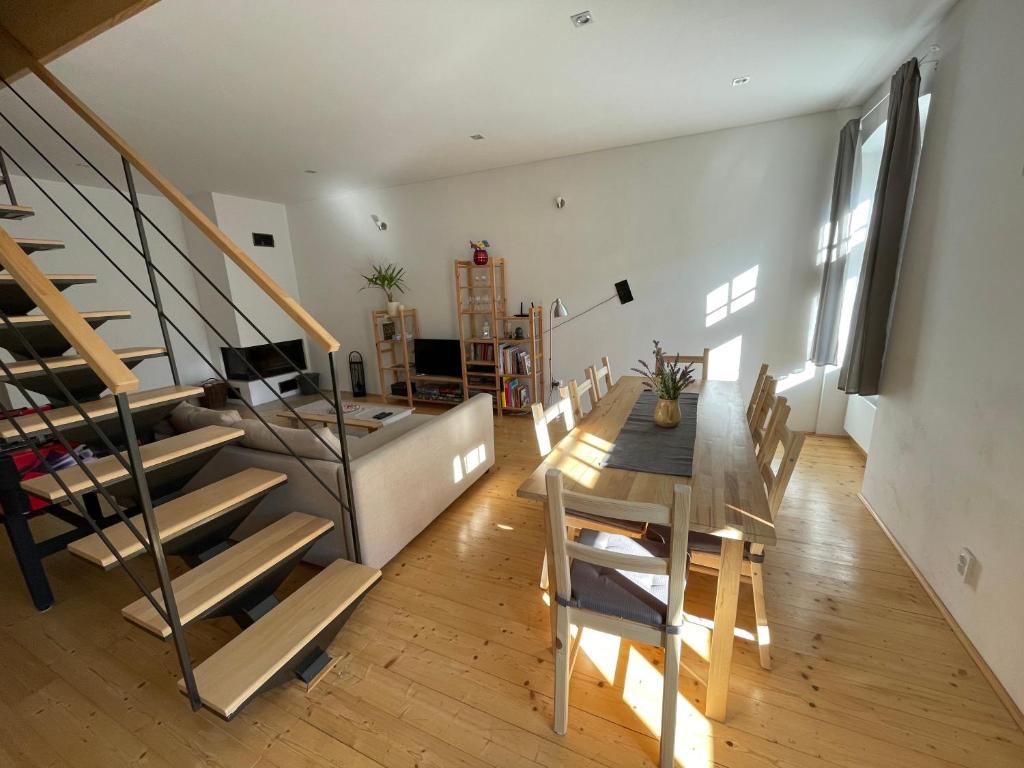 a living room with a staircase and a table and chairs at Apartman Stiavnica in Banská Štiavnica