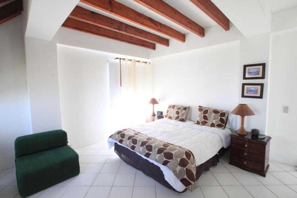 1 dormitorio con 1 cama y 1 silla verde en Apartamento en el Centro de San Andrés Islas con vista al mar- Edificio Bay Point 703, en San Andrés