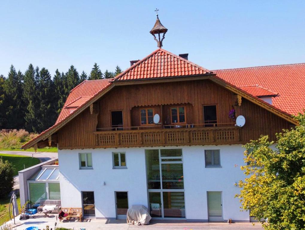 dom z drewnianym dachem i balkonem w obiekcie Idyllische Designer-Apartments am Bio-Bauernhof in SalzburgerSeenland Schmiding 10 w mieście Seekirchen am Wallersee