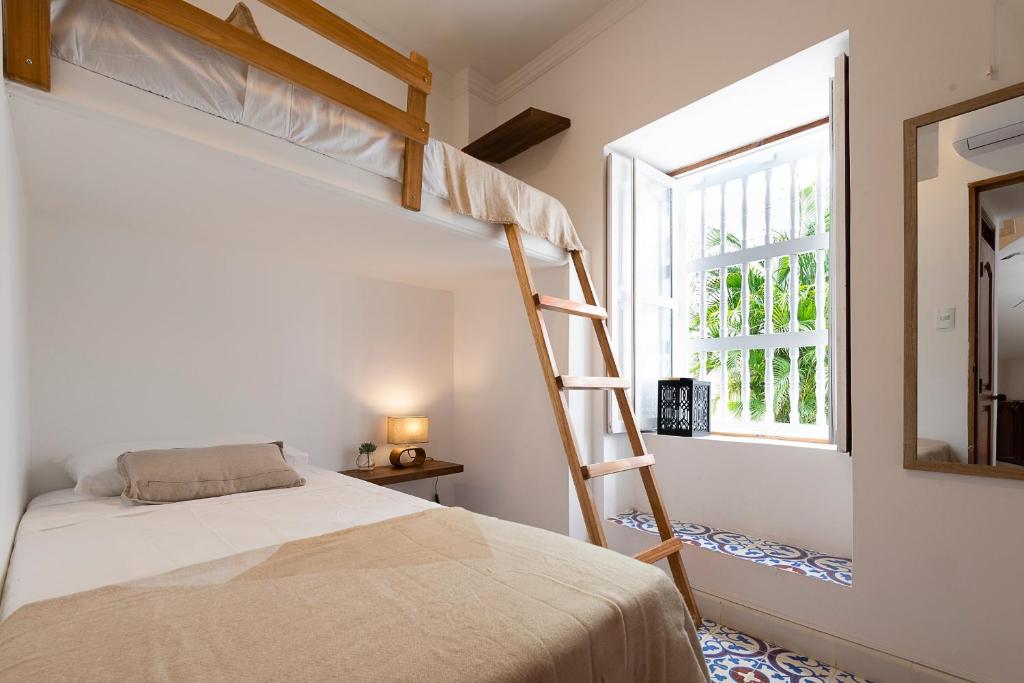 Säng eller sängar i ett rum på La Casita Azul Cozy Colonial House at Centro Historico with Rooftop and Jacuzzi