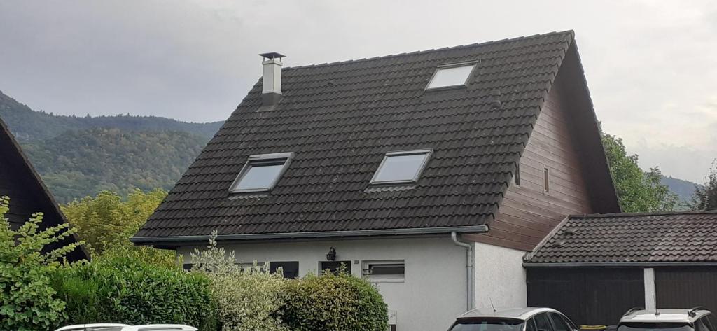 uma casa com um telhado com carros estacionados na frente em Sweet quiet home with garden em Annecy