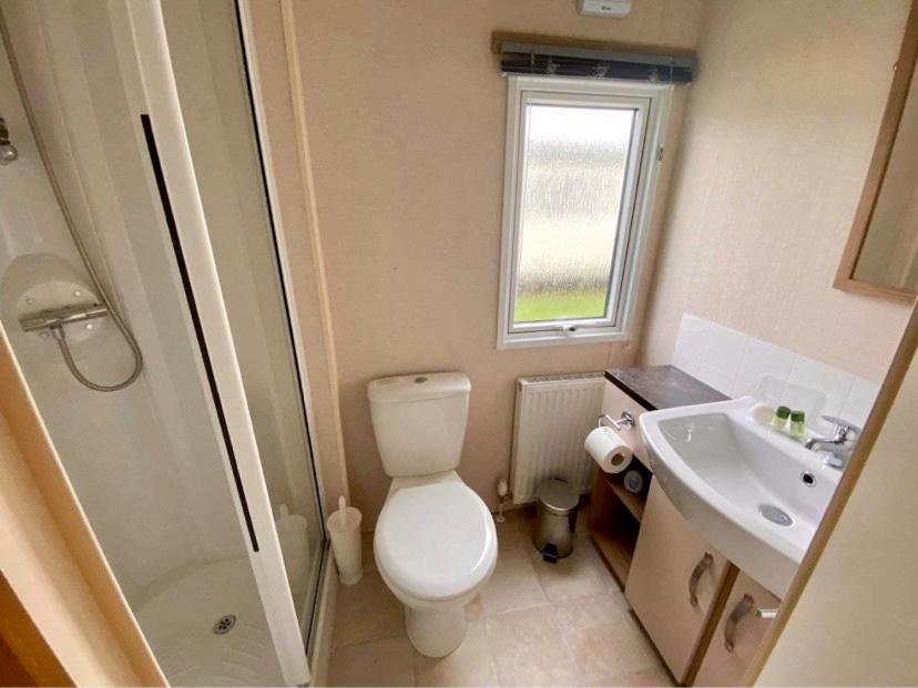 a bathroom with a toilet and a sink at Bude holiday home in Bude