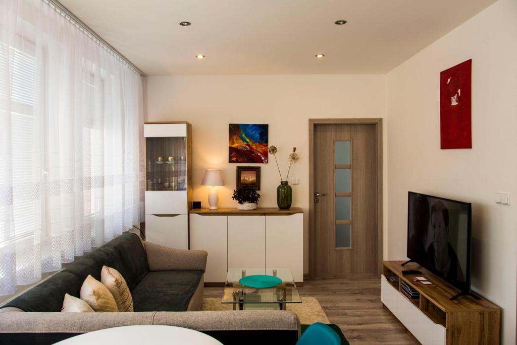 a living room with a couch and a tv at MAYTEX - ubytovanie v 46m2 apartmáne s balkónom in Liptovský Mikuláš
