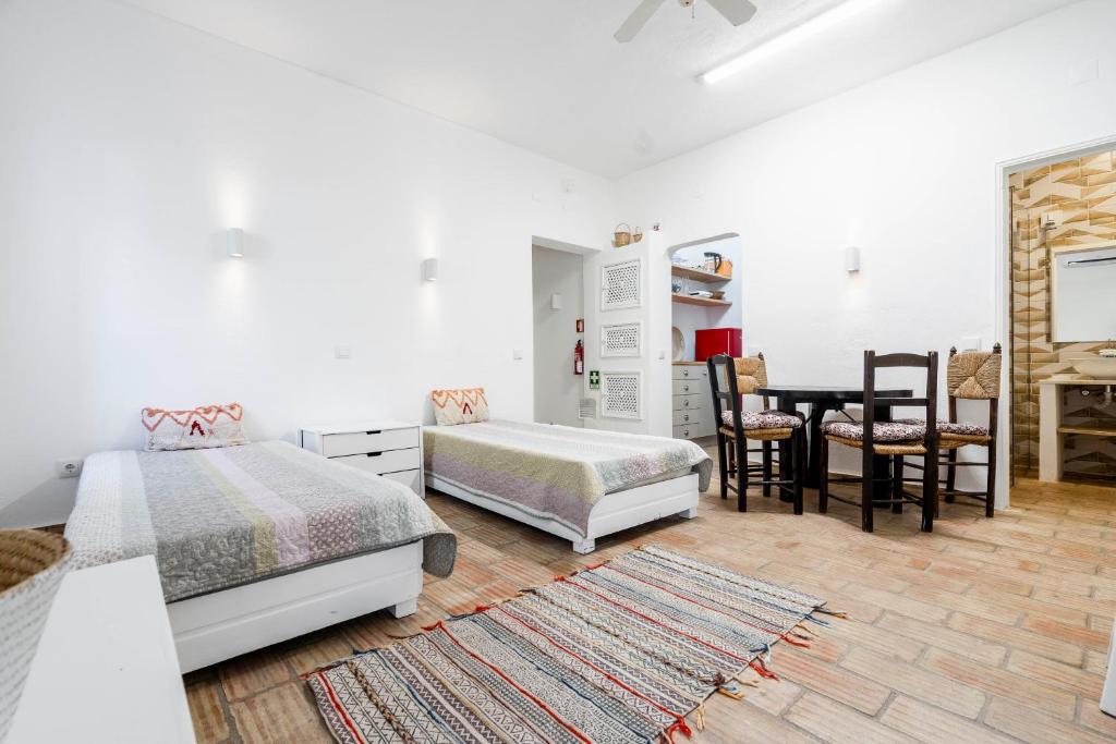 1 Schlafzimmer mit 2 Betten, einem Tisch und Stühlen in der Unterkunft Apartamento 157, Pedras d’el Rei in Tavira