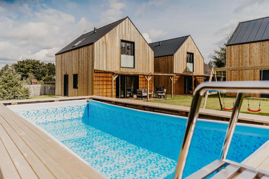 a barn conversion with a swimming pool in front of a house at Sun House in Nadole