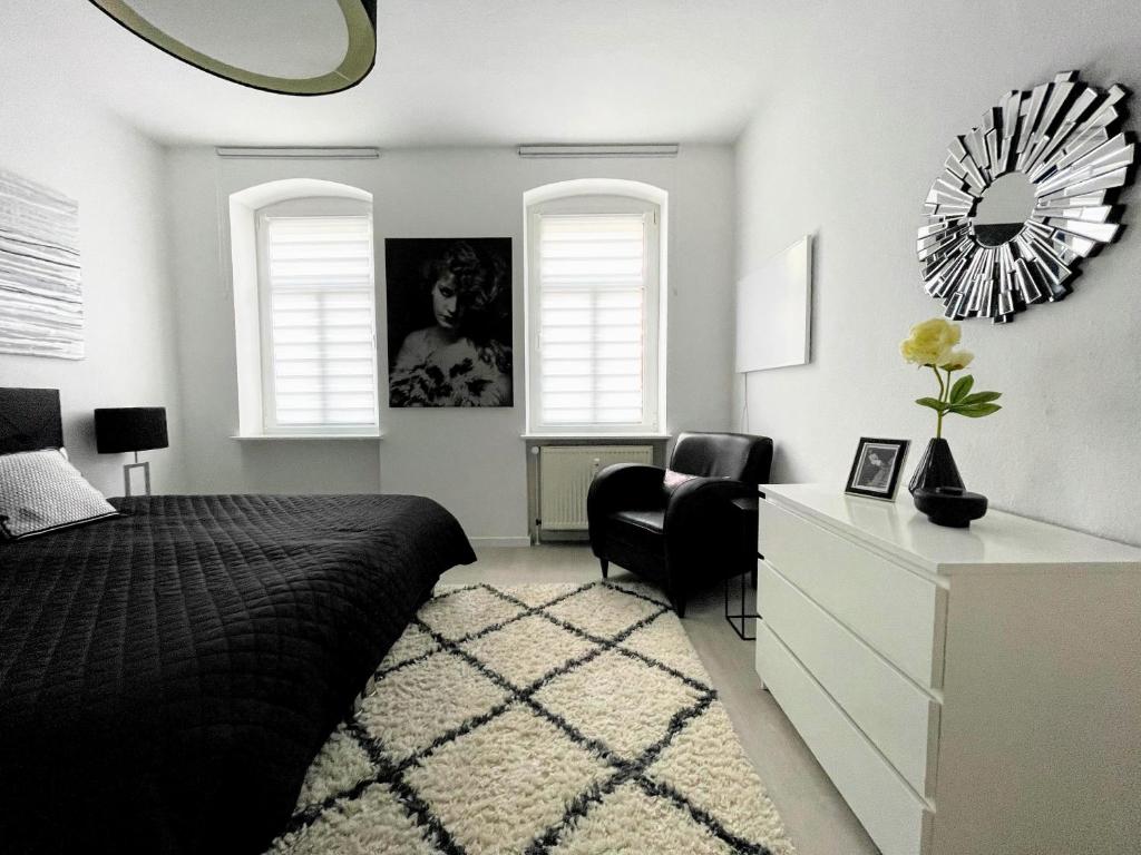 a bedroom with a bed and a dresser and a mirror at BAUHAUS Design-Luxus Apartment, 20er Jahre Stil, Garten in Gera