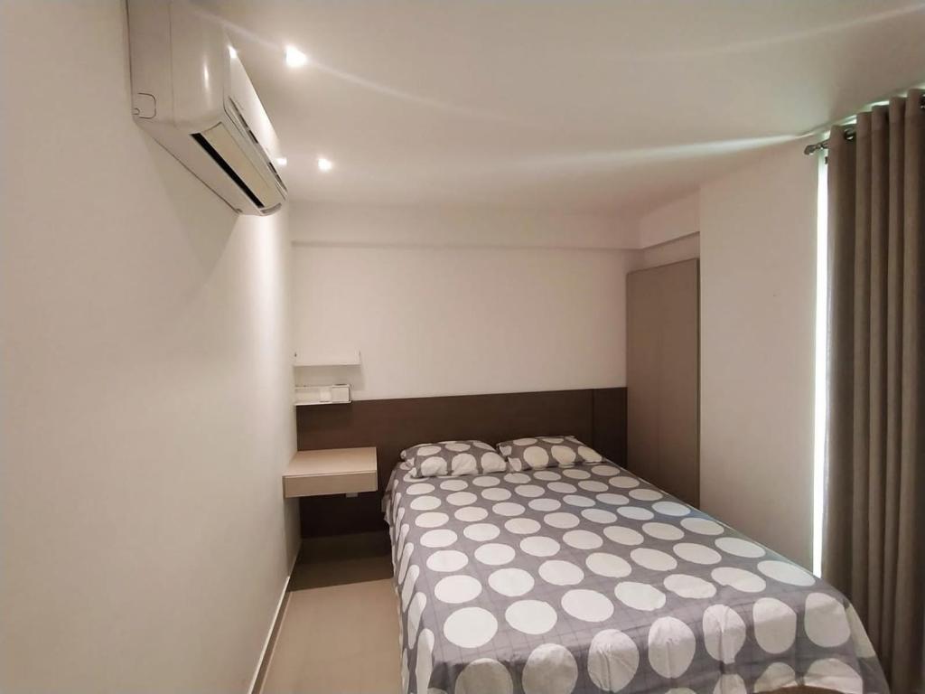 a small bedroom with a bed in a room at Premium Flat Praia Calma - PontaNegra in Natal