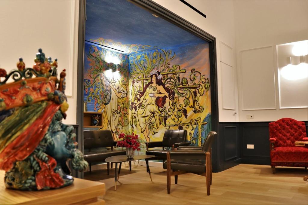 a living room with a large painting on the wall at Vespri Luxury Rooms & Suites in Palermo