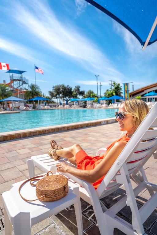 a woman sitting in a chair next to a pool at Sun Outdoors Sarasota in North Sarasota