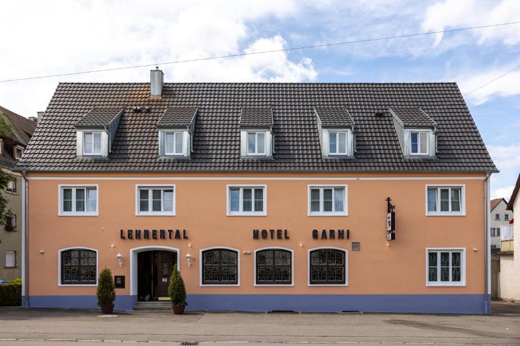 ein großes orangefarbenes Haus mit schwarzem Dach in der Unterkunft Hotel Garni Lehrertal in Ulm