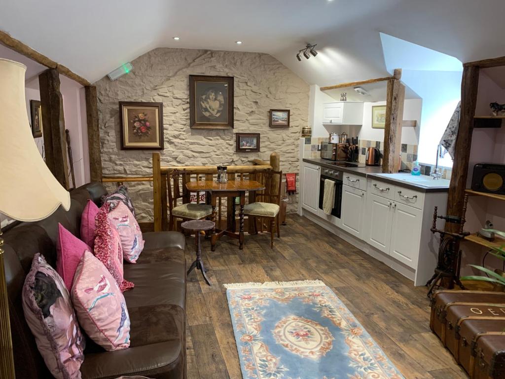 a living room with a couch and a kitchen at Brecon Boutique Breaks River Run in Sennybridge