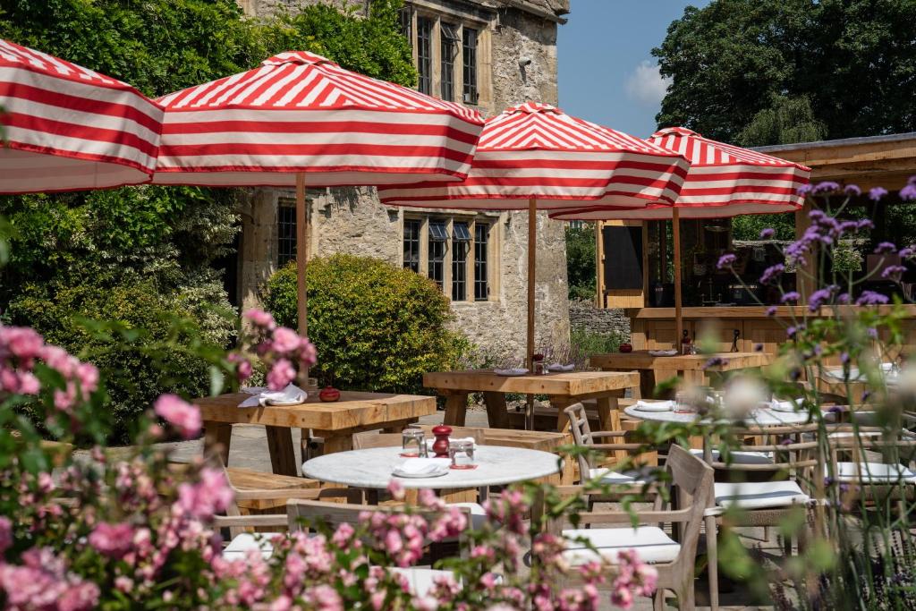 a picnic table with umbrellas on a patio at The Double Red Duke, Cotswolds in Clanfield