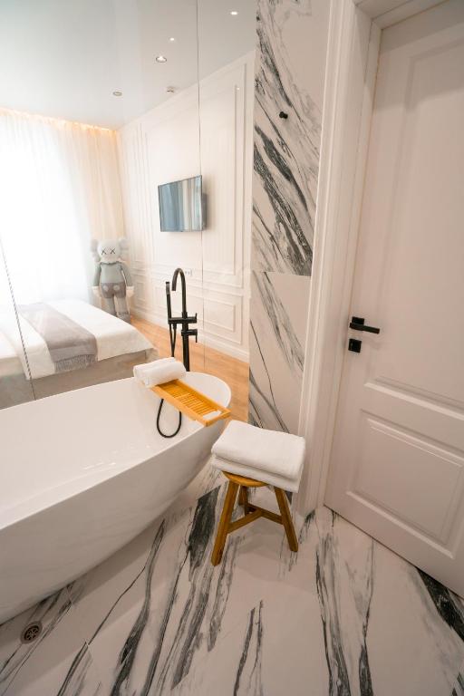 a bathroom with a tub and a chair and a bed at Suite Hotel in Kemerovo