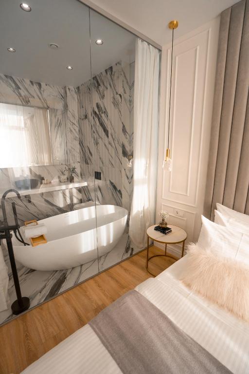 a bathroom with a tub and a bed and a bath tub at Suite Hotel in Kemerovo