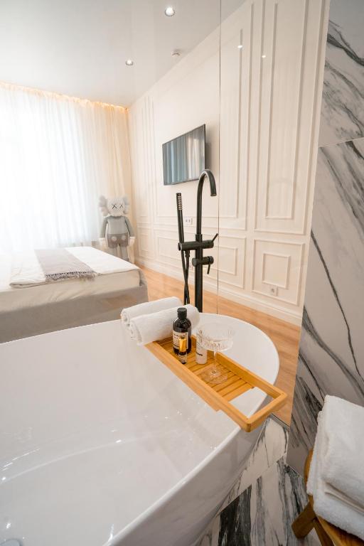 a bathroom with a tub and a sink in a room at Suite Hotel in Kemerovo