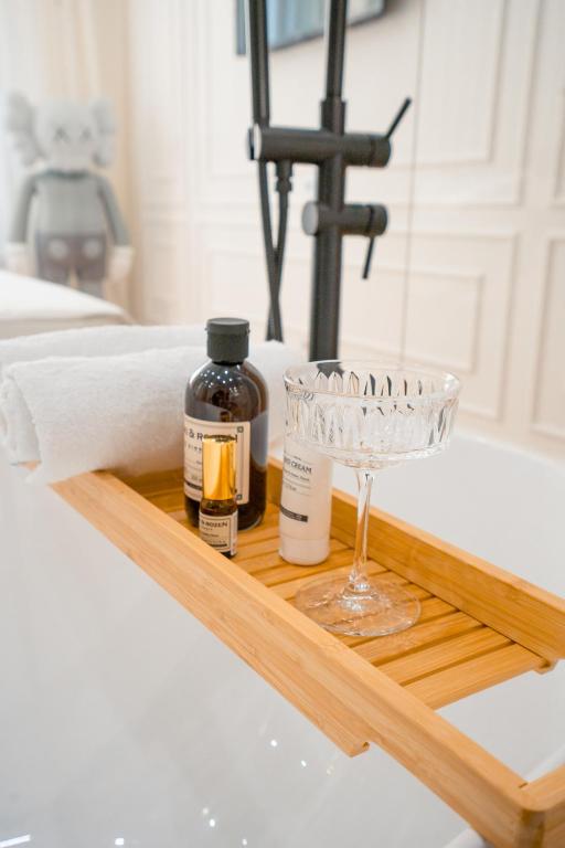 a wooden tray with a glass on a bathroom sink at Suite Hotel in Kemerovo