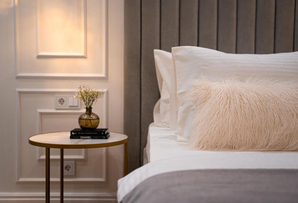 a bed with a white pillow and a table next to it at Suite Hotel in Kemerovo