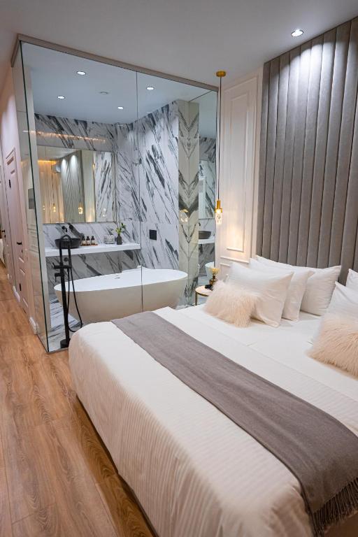 a large bedroom with a large bed and a bath tub at Suite Hotel in Kemerovo