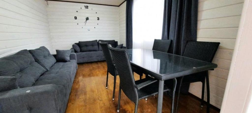 uma sala de estar com uma mesa e um sofá em Новый дом целиком 800м от моря за городом в тихом уютном месте em Chornomorsk