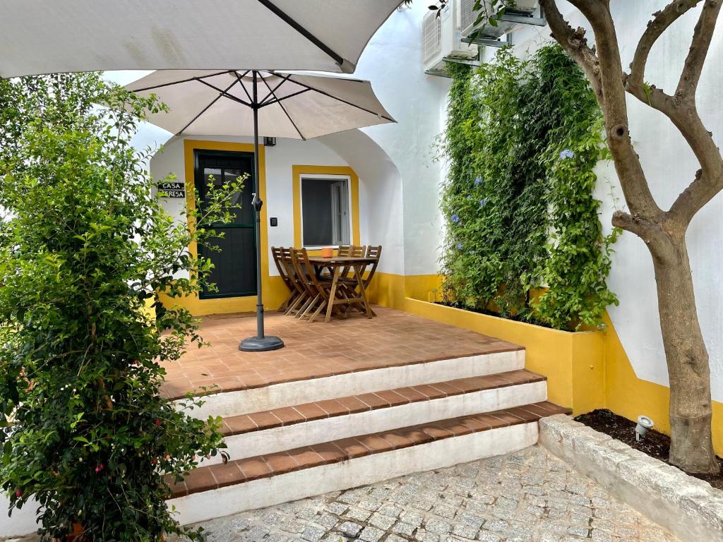 a patio with stairs and an umbrella in front of a house at Casa Teresa in Évora