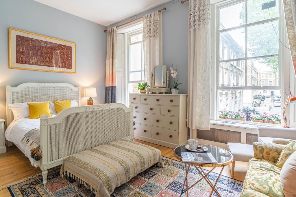 - une chambre avec un lit, un canapé et des fenêtres dans l'établissement House close to kings cross, à Londres