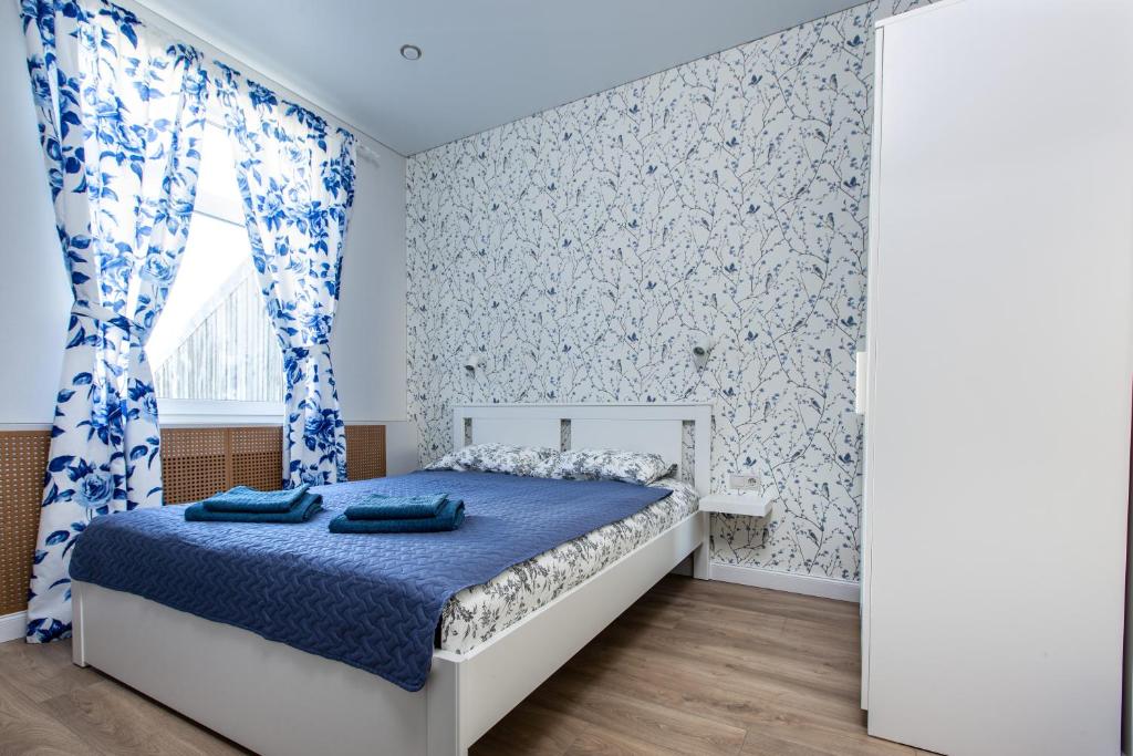 een slaapkamer met een bed met blauw en wit behang bij à la fontaine in Druskininkai