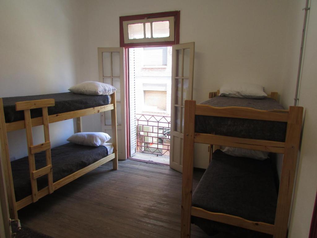 een kamer met twee stapelbedden en een raam bij CASA ARTIGAS Hostel in Cordoba