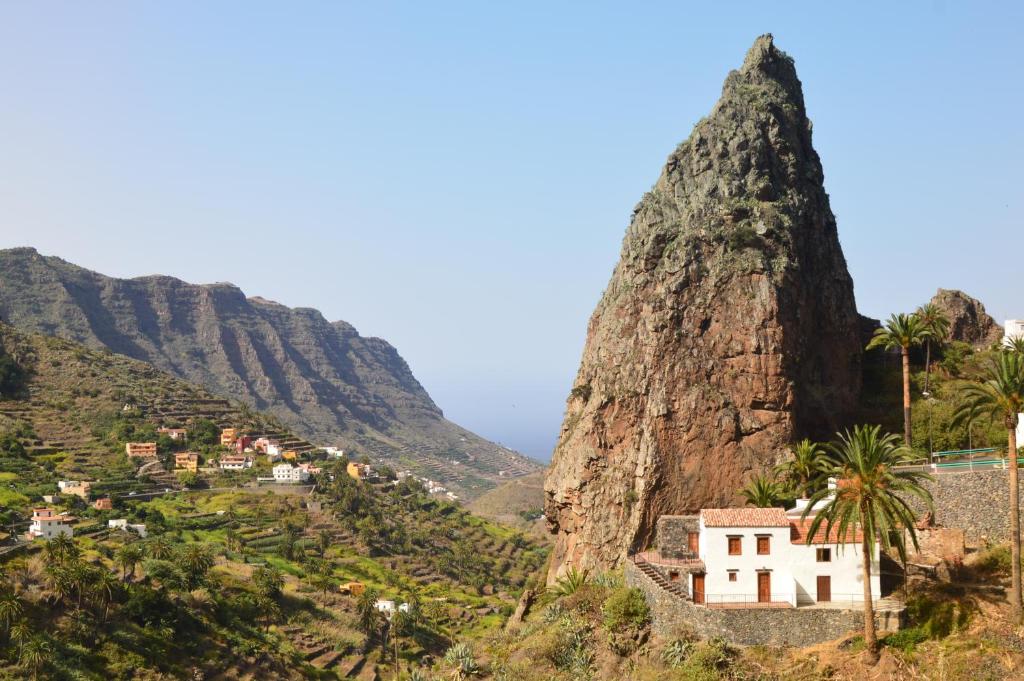 a view of a mountain with a village and palm trees at Casa Rural El Mantillo in Hermigua