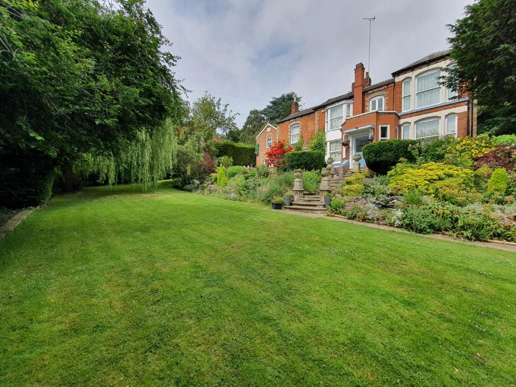 une grande cour avec une maison et une pelouse dans l'établissement Spectacular Period Property Located In Leicester, à Leicester
